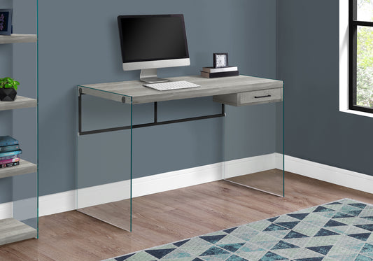 Modern grey wood computer desk with clear glass legs and single drawer
