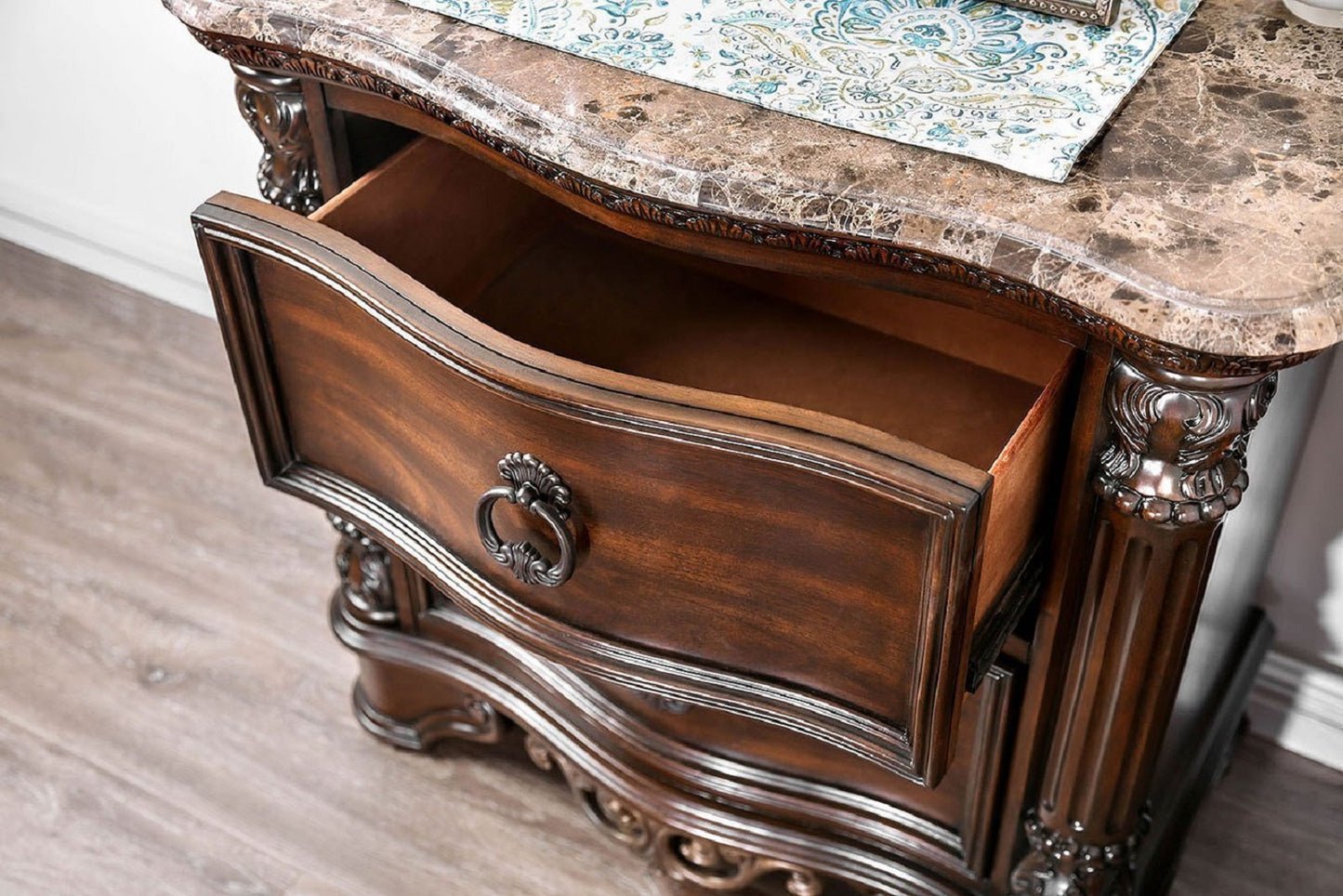 Dark wood nightstand with open drawer and ornate metal pull