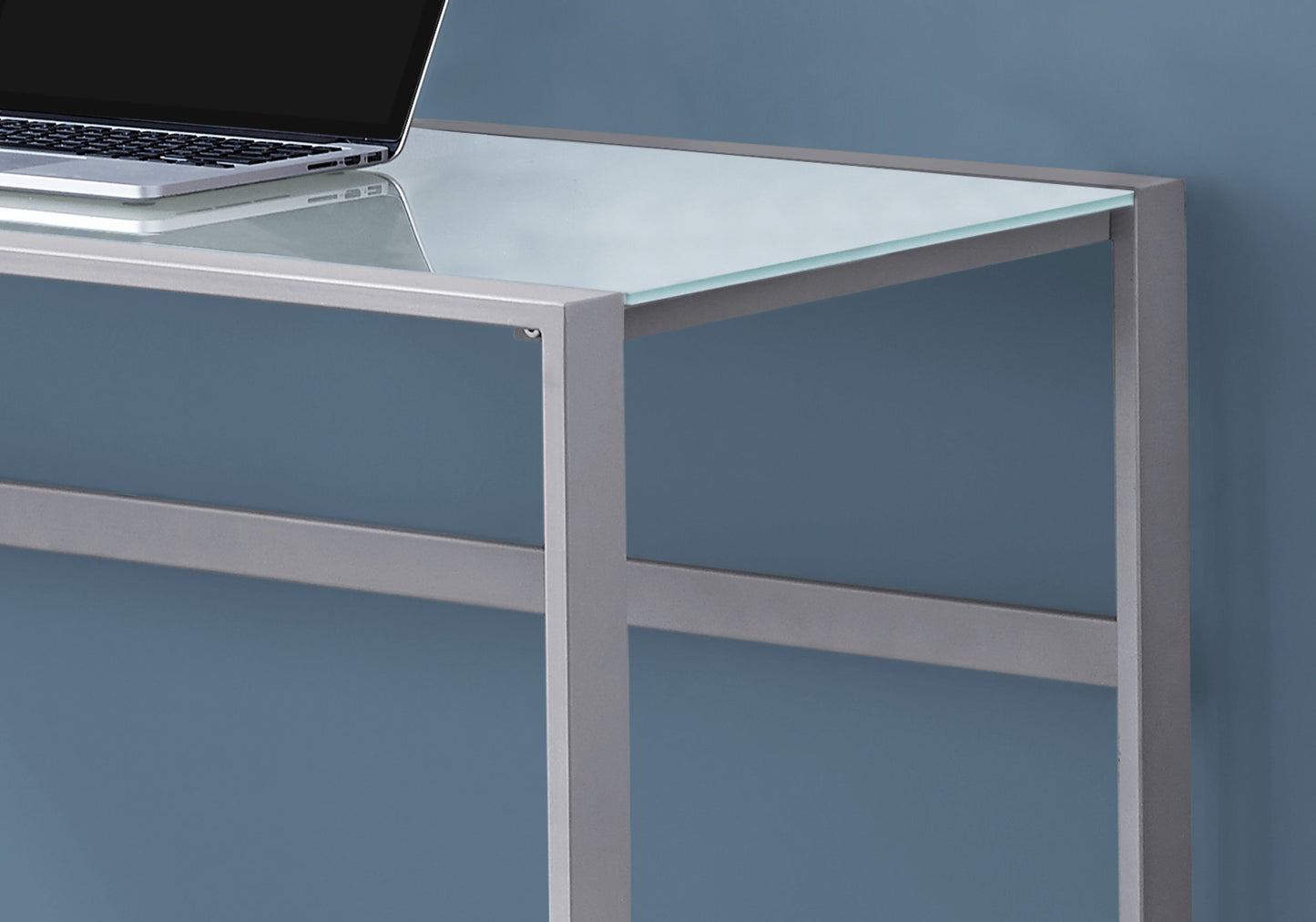 Modern glass desk with silver metal frame and a laptop