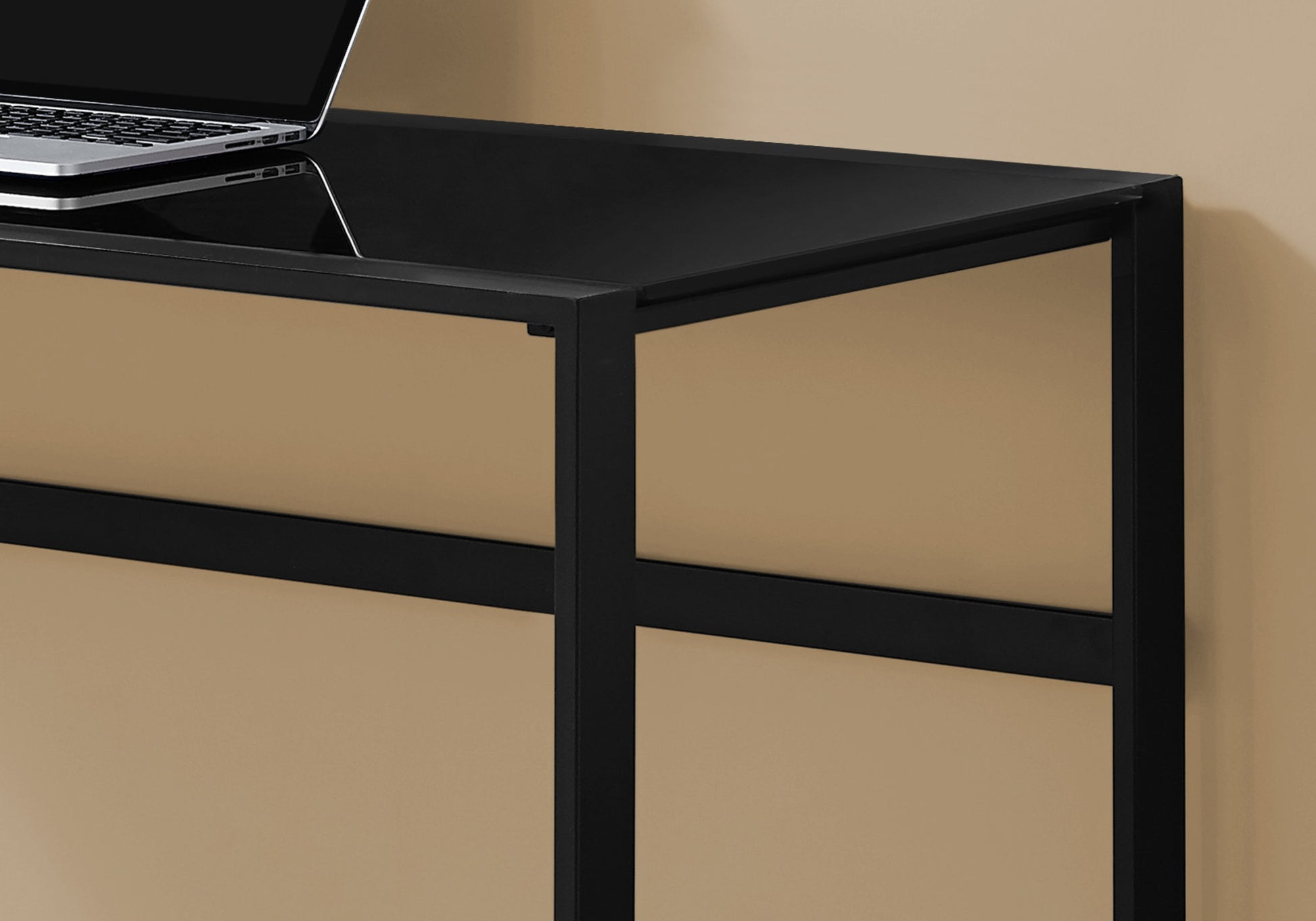 Sleek black glass desk with metal frame and laptop for a modern home office