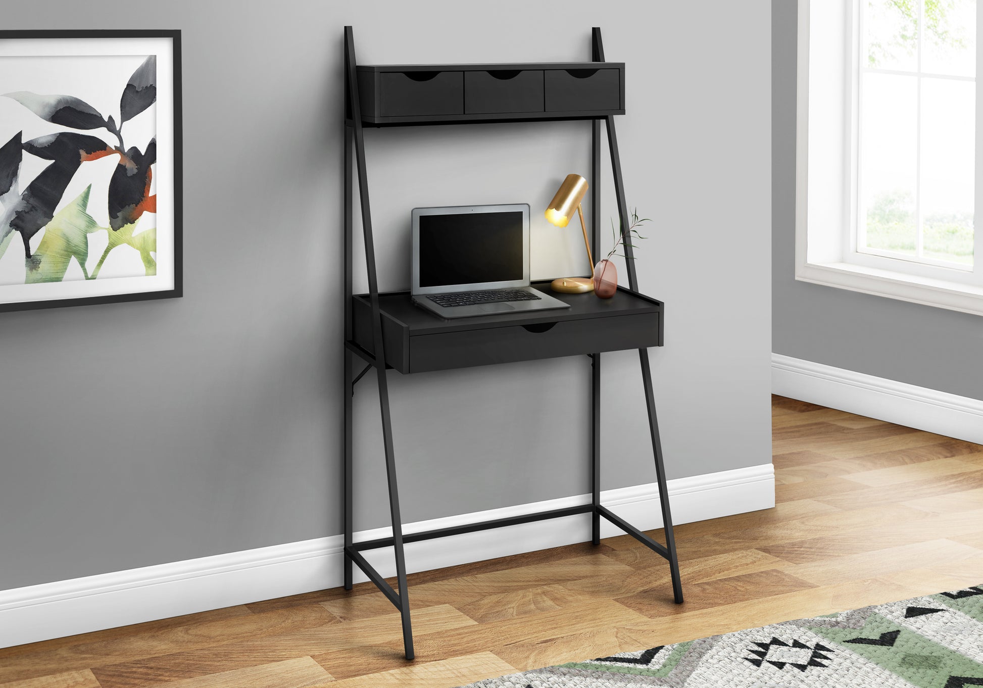Black ladder desk with three drawers and a laptop perfect for home office
