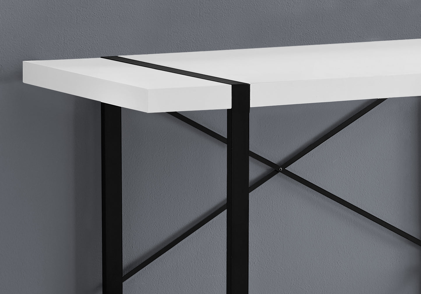 Closeup of a white laminate console table with black metal crisscross legs