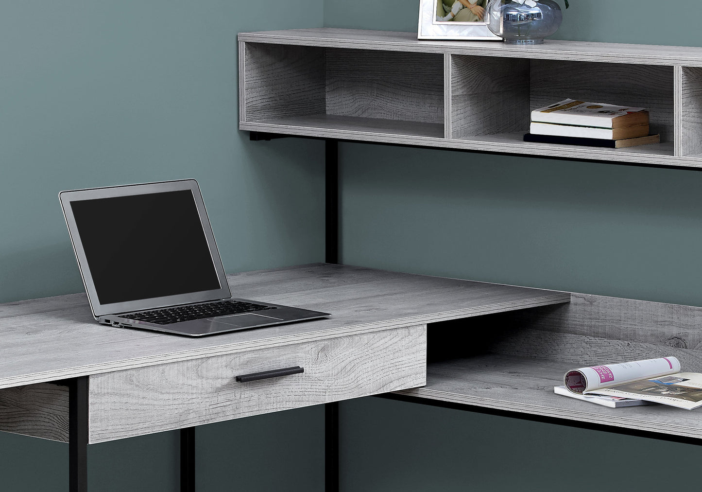 Gray wood grain desk with open shelving and laptop