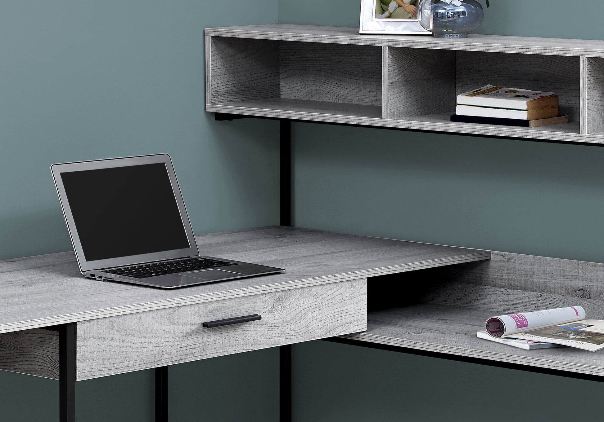 Gray wood grain desk with open shelving and laptop