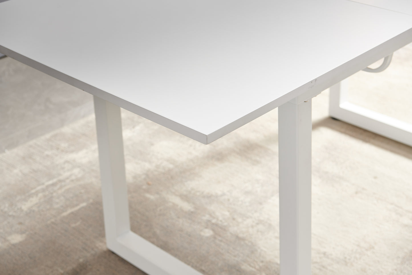Closeup of a white modern desk with a simple frame perfect for home offices