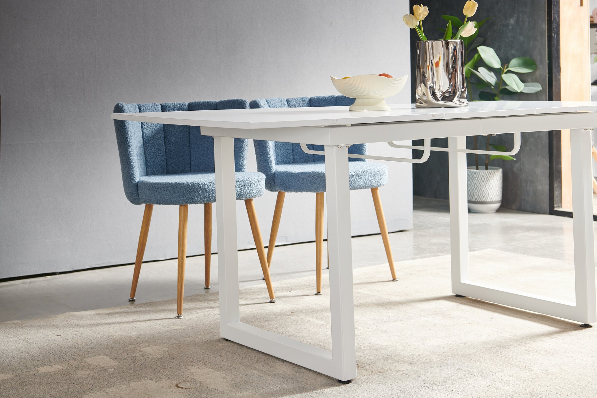 Modern white rectangular dining table with wooden legs and fluffy blue dining chairs