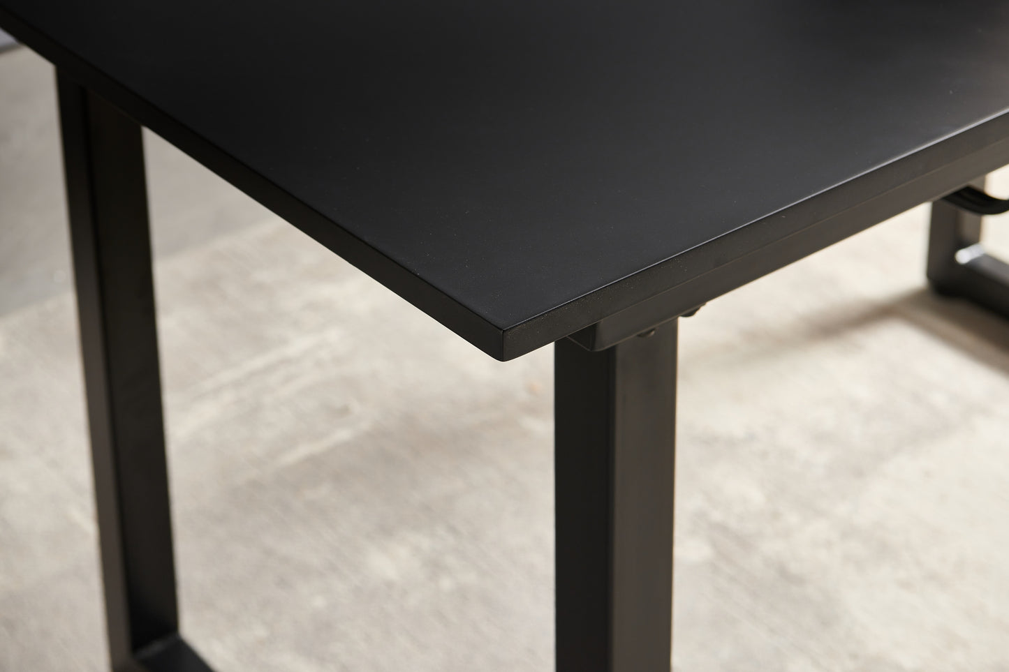 Closeup of a sleek black metal desk with minimalist legs perfect for a modern office