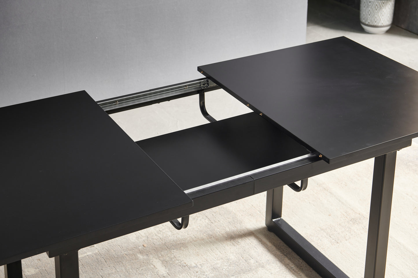 Black extendable dining table with metal legs adaptable for various kitchen spaces