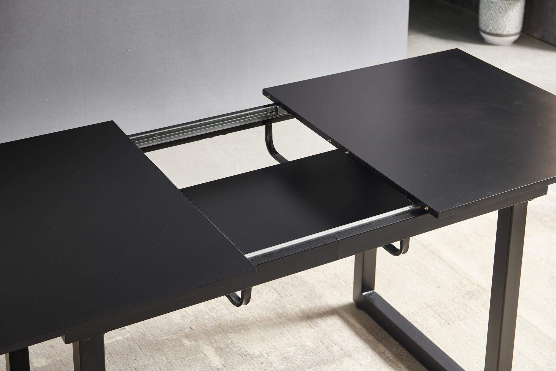 Black extendable dining table with metal legs adaptable for various kitchen spaces