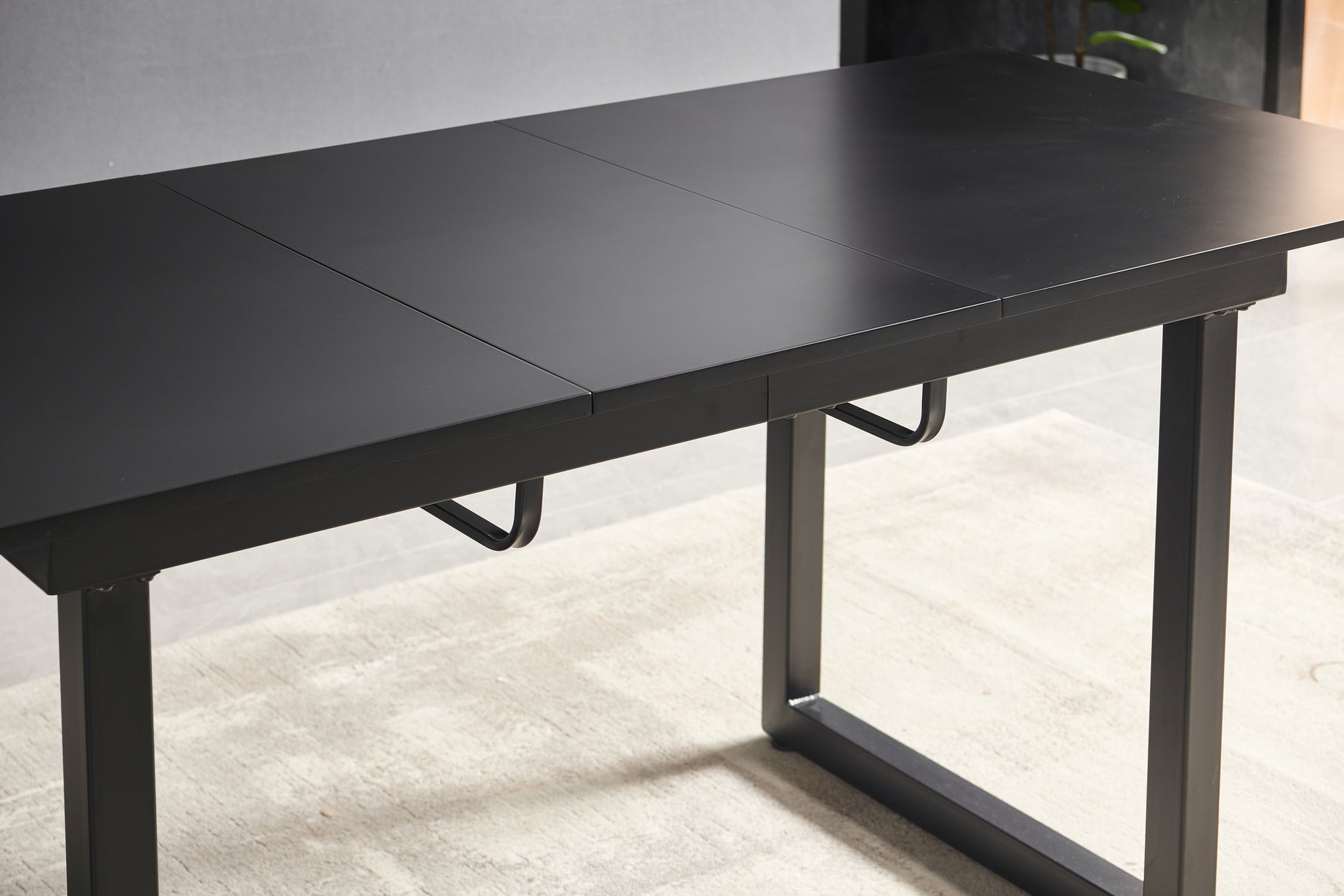 Minimalist black extendable dining table with matte finish and metal legs