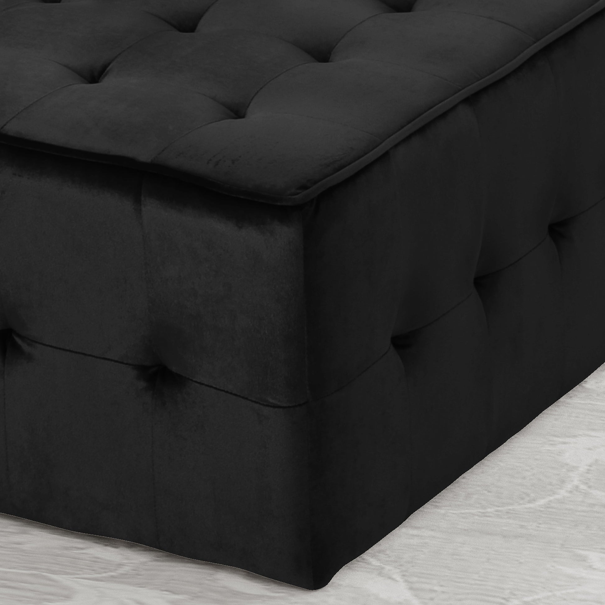 Black velvet storage ottoman with tufted lid and side accents
