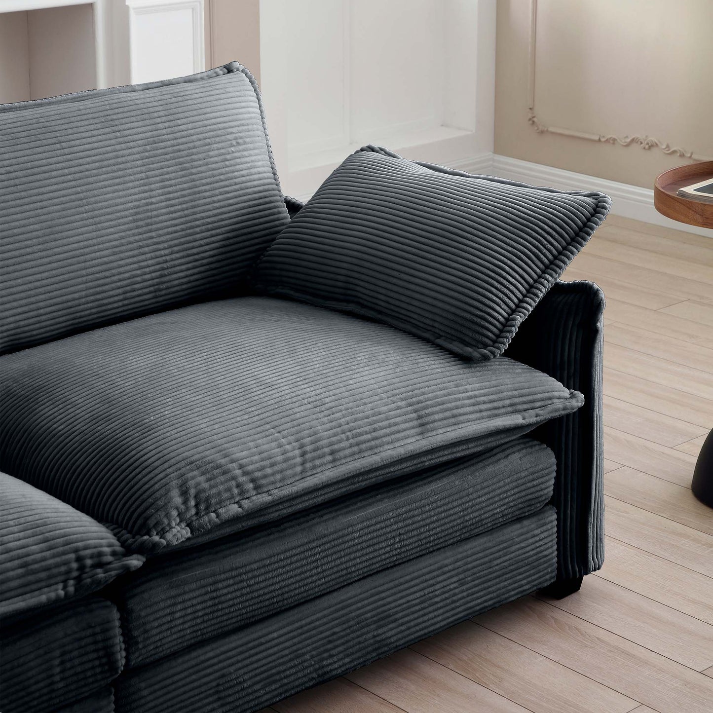 Plush dark grey corduroy sofa with deep seating and matching accent pillow for ultimate comfort