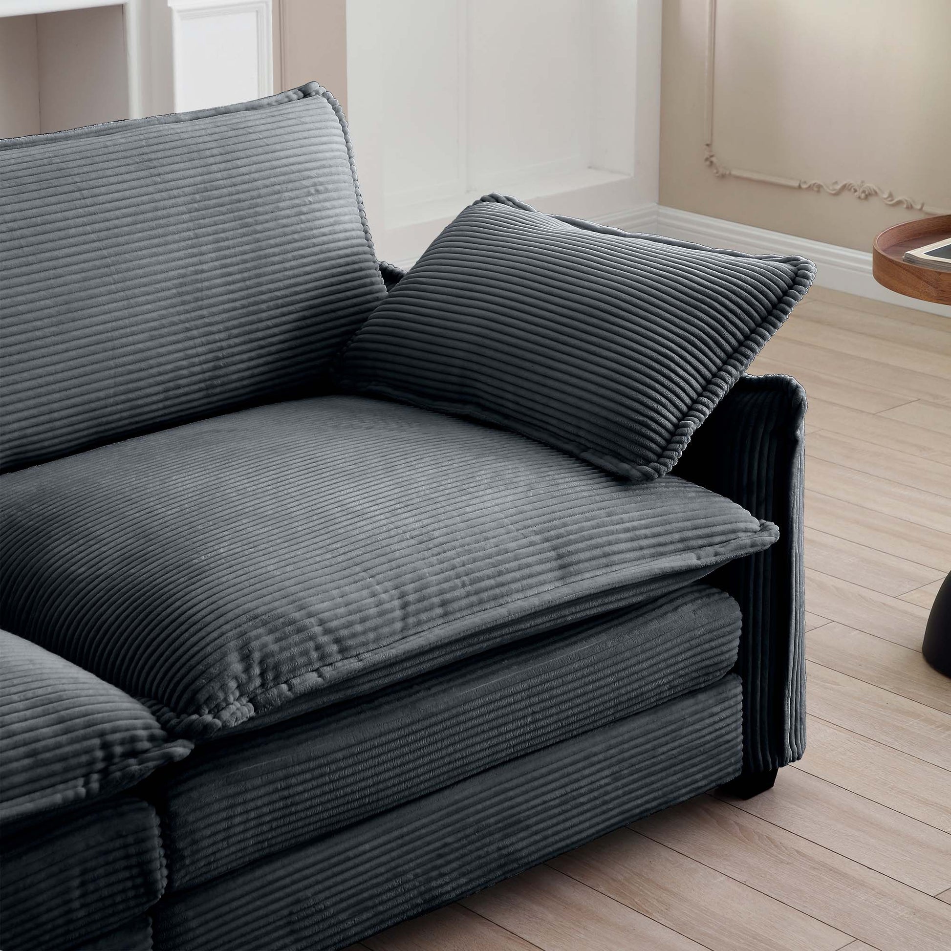 Plush dark grey corduroy sofa with deep seating and matching accent pillow for ultimate comfort