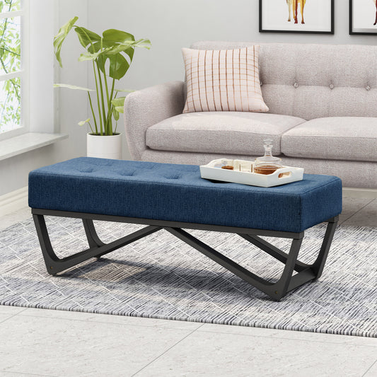 Blue tufted ottoman bench with black metal legs on a patterned rug