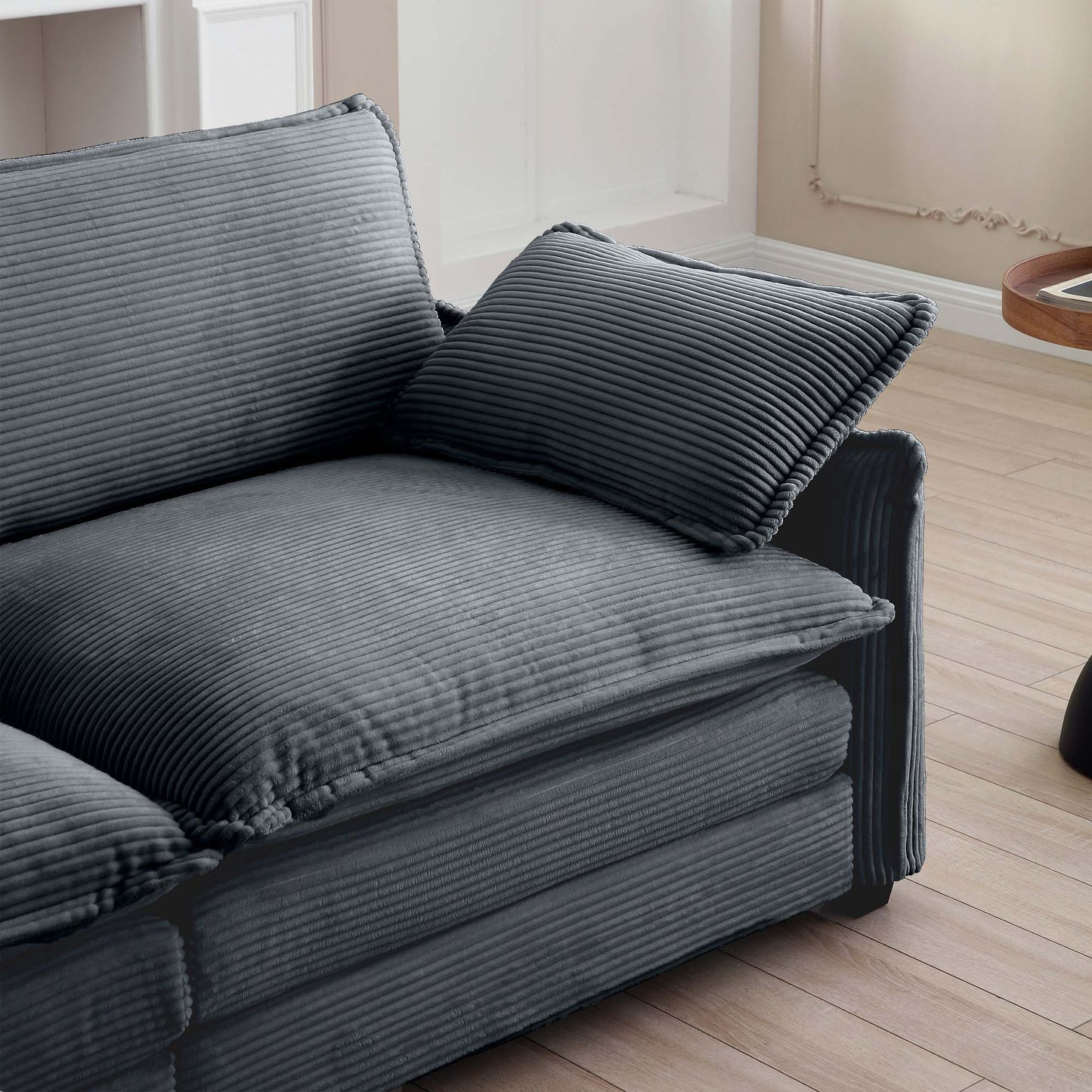 Plush grey corduroy sofa with deep comfortable cushions and a matching throw pillow