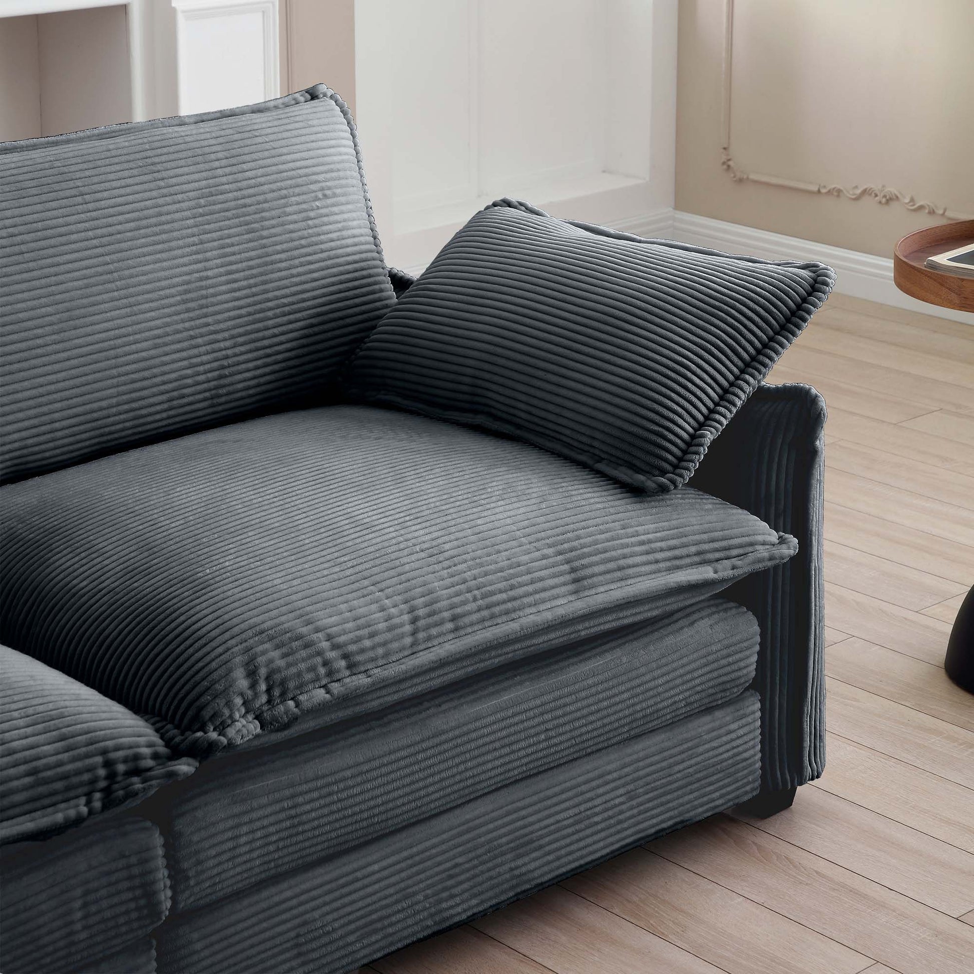 Plush grey corduroy sofa with deep comfortable cushions and a matching throw pillow