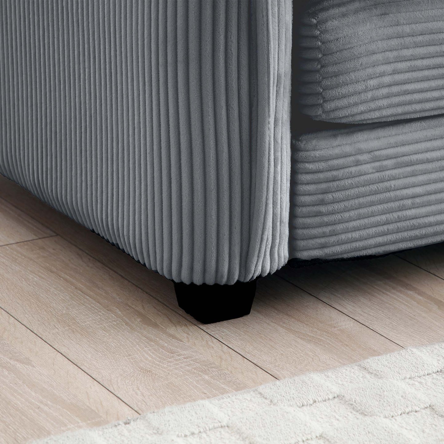 Grey corduroy sofa fabric closeup showing vertical wale texture