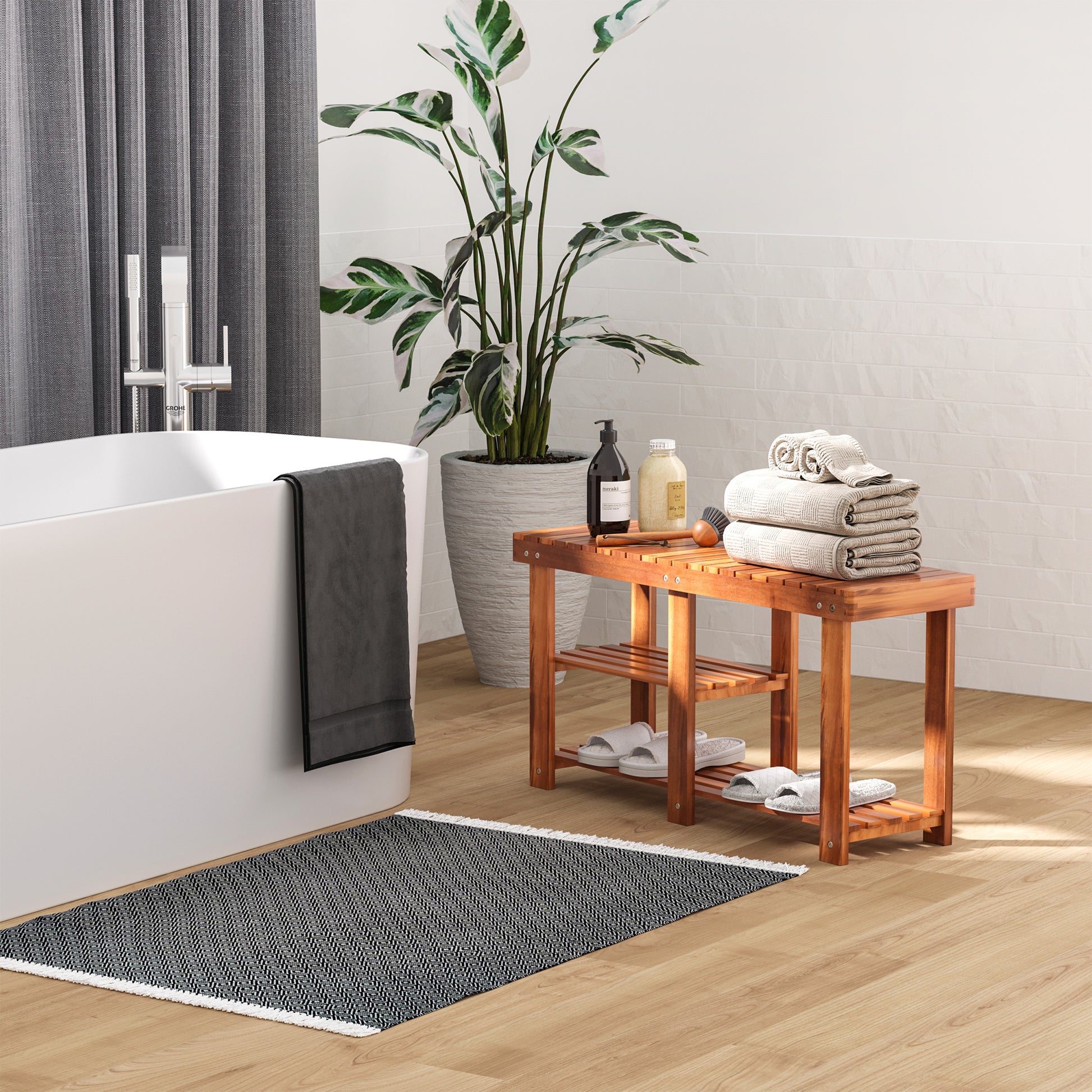 Dark gray geometric pattern bath mat with white fringe on wooden floor