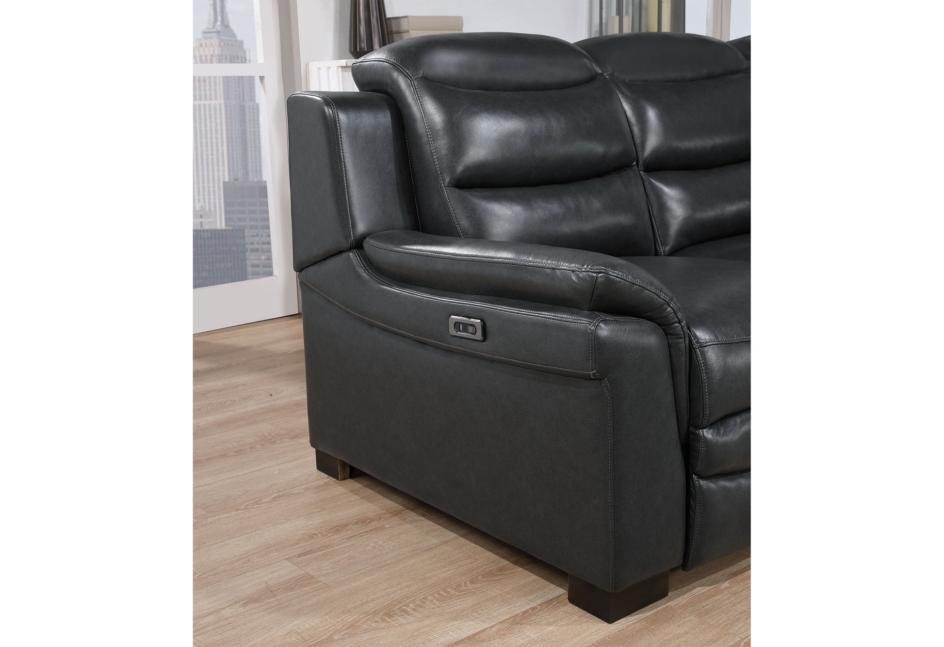 Closeup of a charcoal gray leather recliner sofa with stitched detailing and power control button