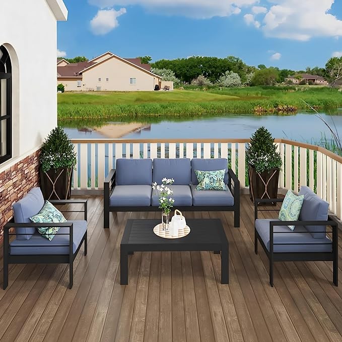 Black aluminum patio furniture set with blue cushions including sofa chairs and coffee table