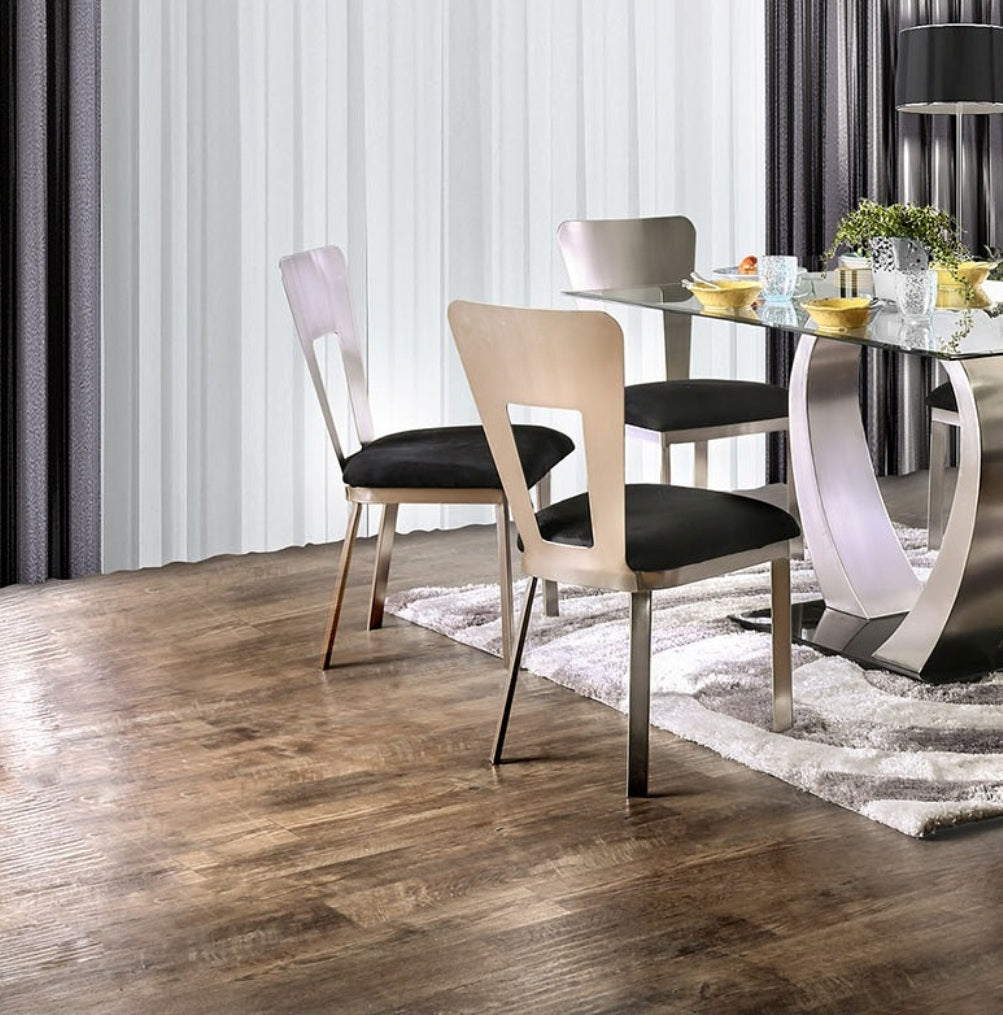 Modern dining chairs with silver frames and black cushions around a glass table
