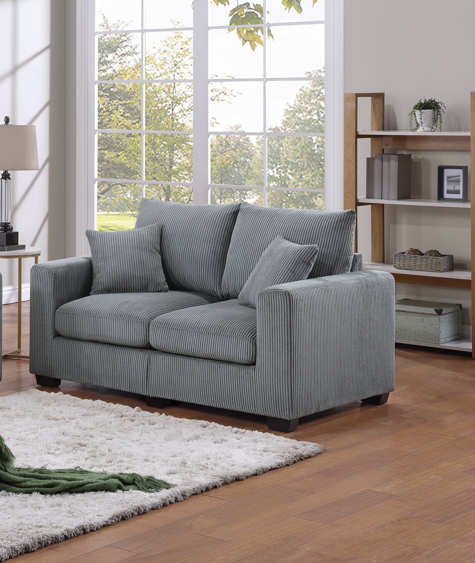 Grey corduroy loveseat with plush cushions and matching throw pillows