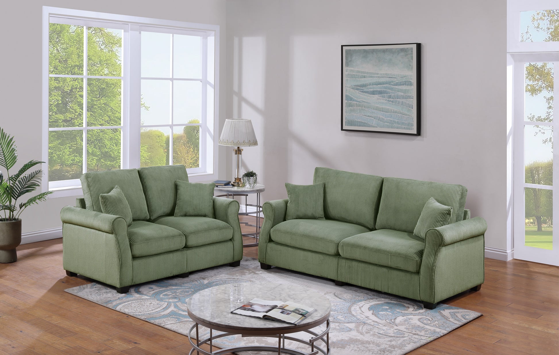 A plush sage green corduroy sofa with rolled arms and matching throw pillows sits in a living room