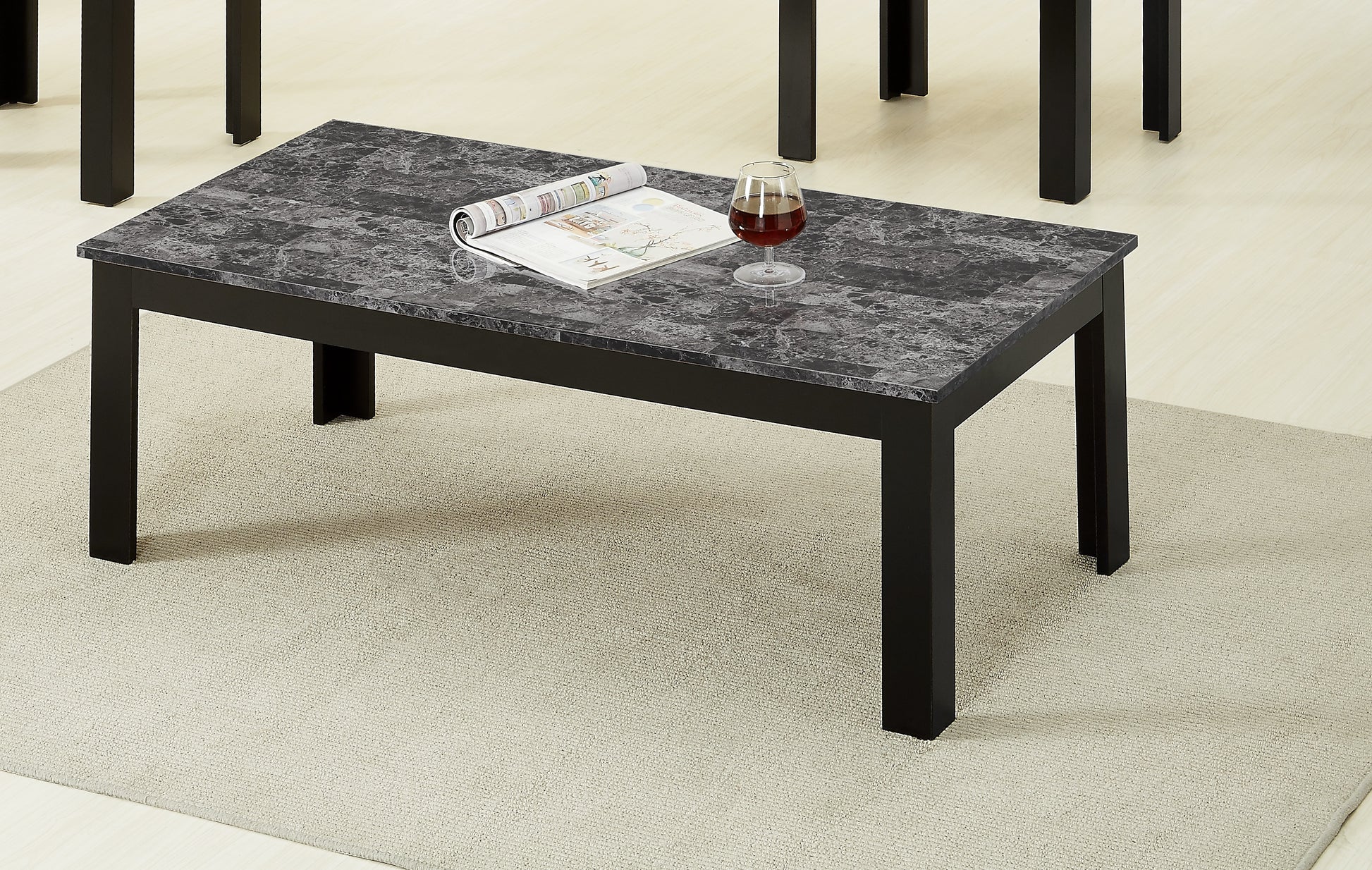 Modern rectangular coffee table with black metal legs and a gray marblelook top surface