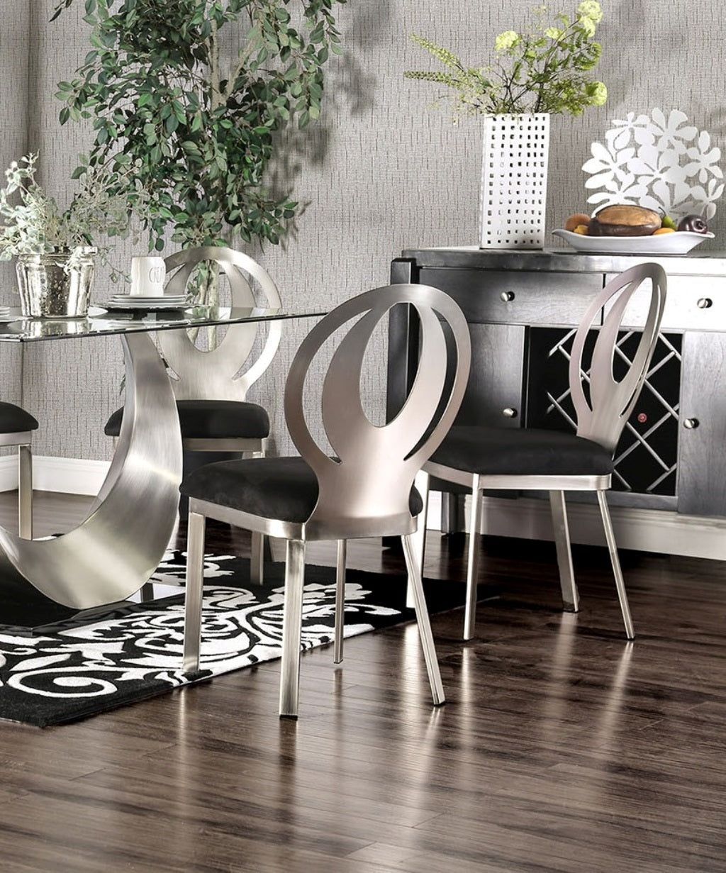 Contemporary silver dining chairs with black velvet seats featuring unique curved backrests