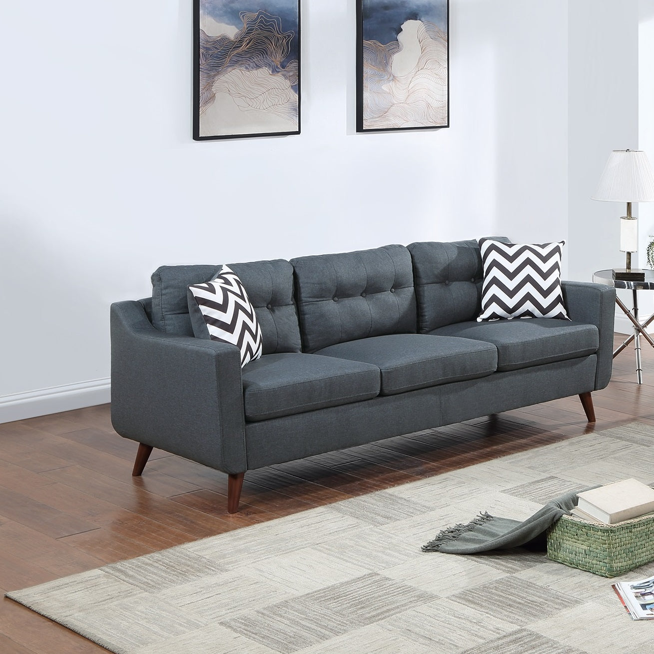 Dark grey upholstered sofa with tufted back and chevron pillows