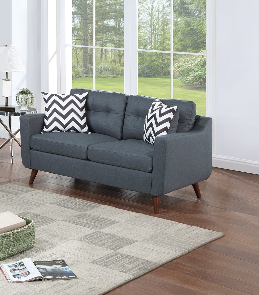 Tufted charcoal grey loveseat with chevron pillows and wooden legs