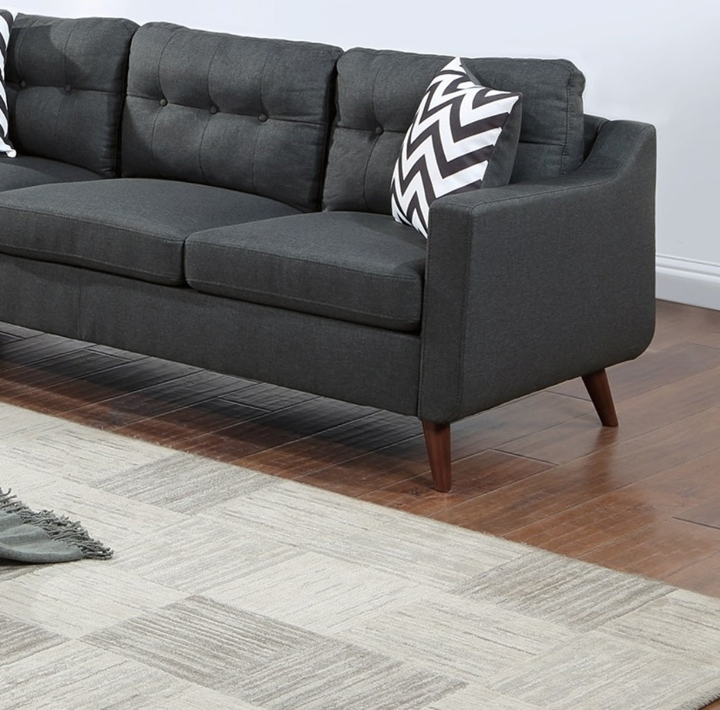 Dark gray upholstered sofa with tufted back cushions and modern wooden legs