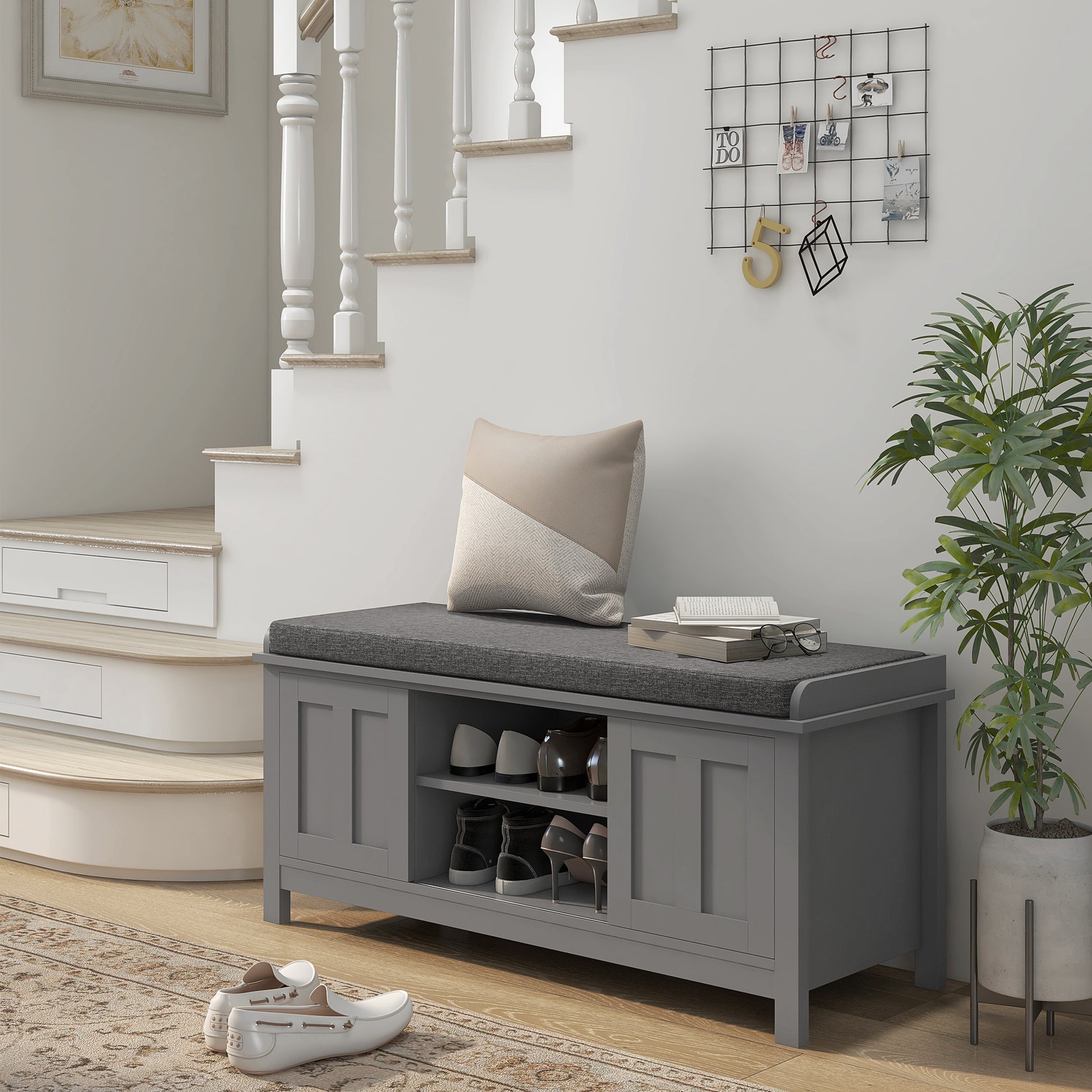Gray entryway shoe bench with upholstered seat and storage compartments