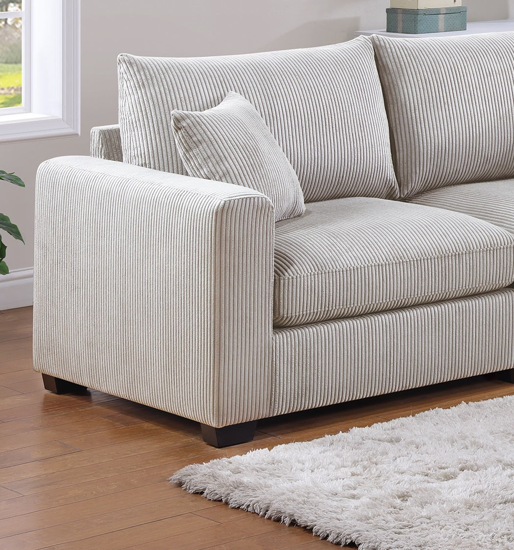 Cream corduroy sofa with plush cushions and matching accent pillow