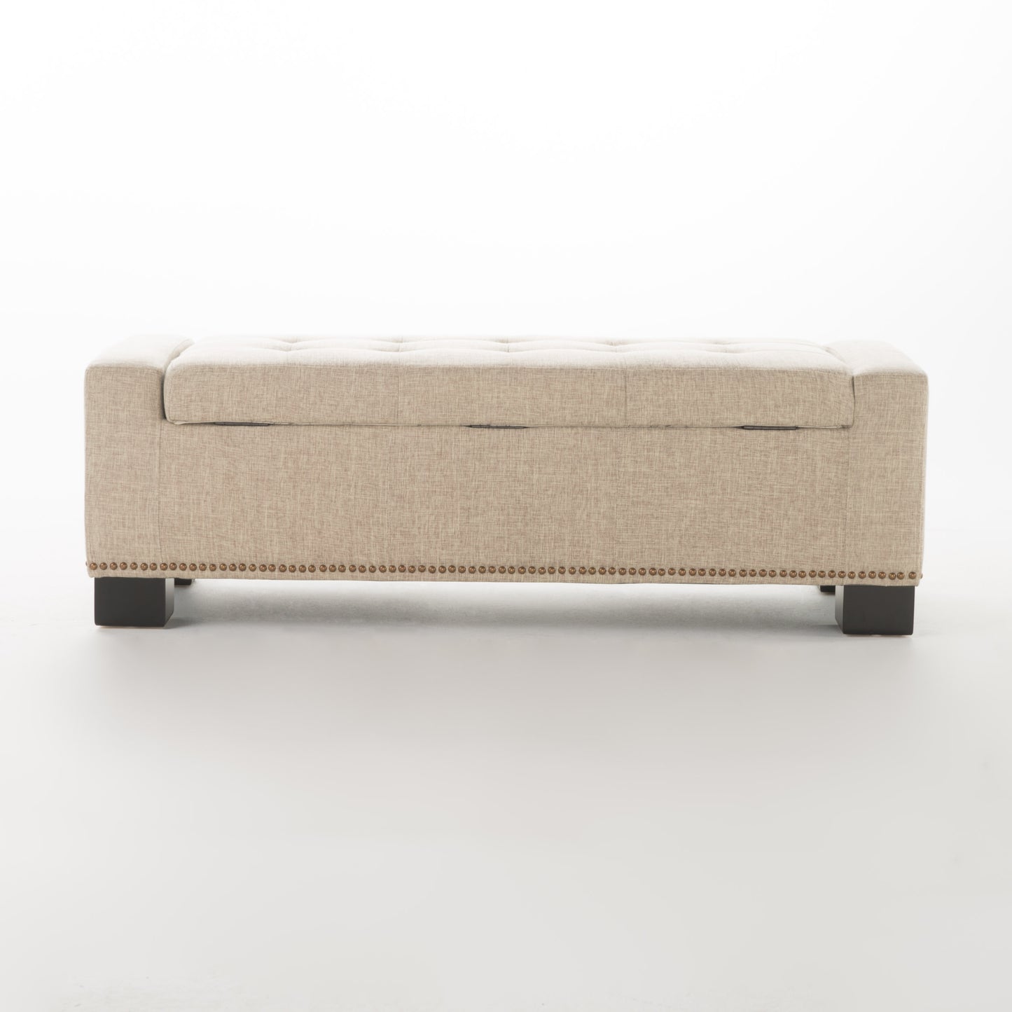 Beige tufted storage ottoman with brass nailhead trim