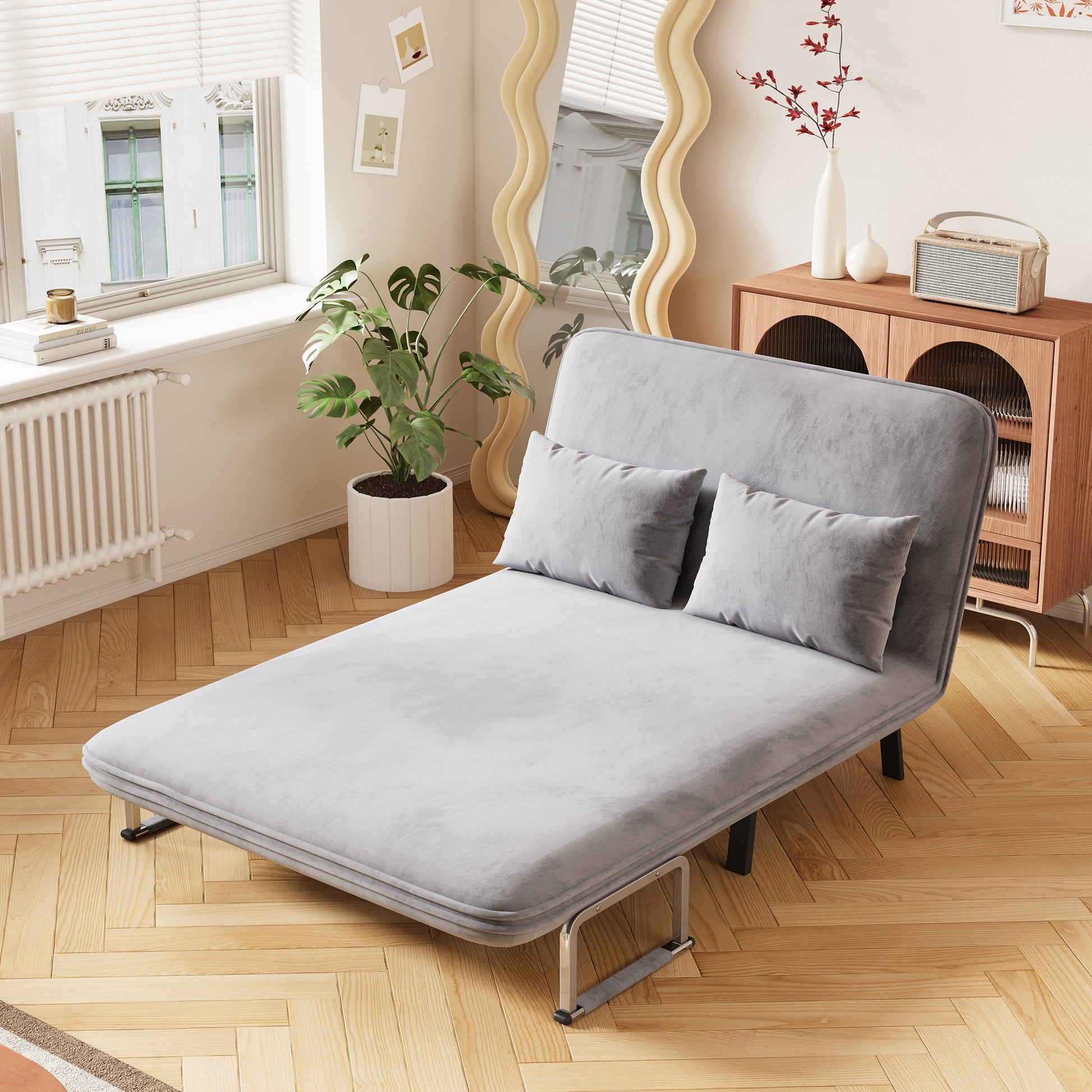 Grey velvet daybed with metal frame and two square pillows for lounging