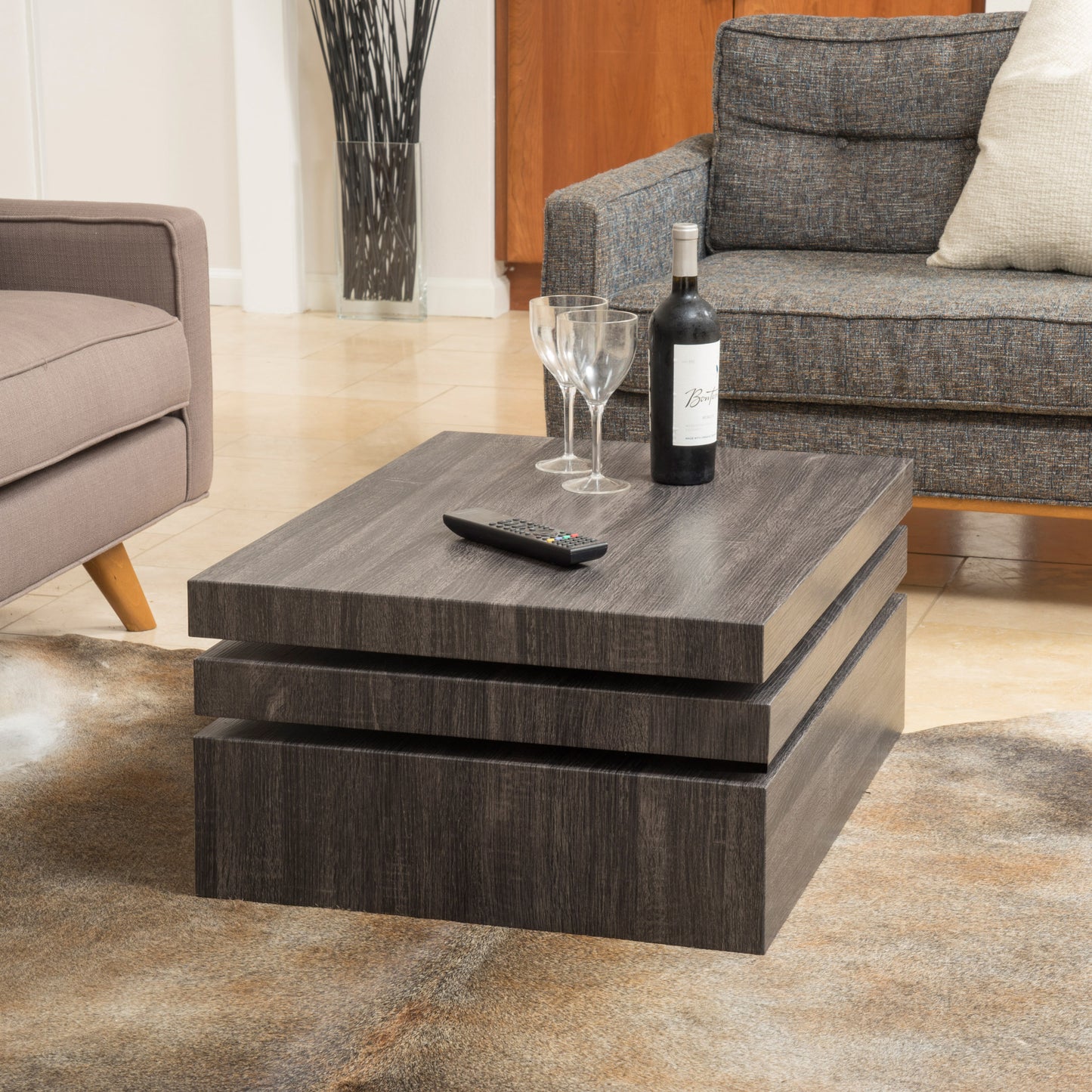 Modern dark wood stacked coffee table with remote and wine glasses