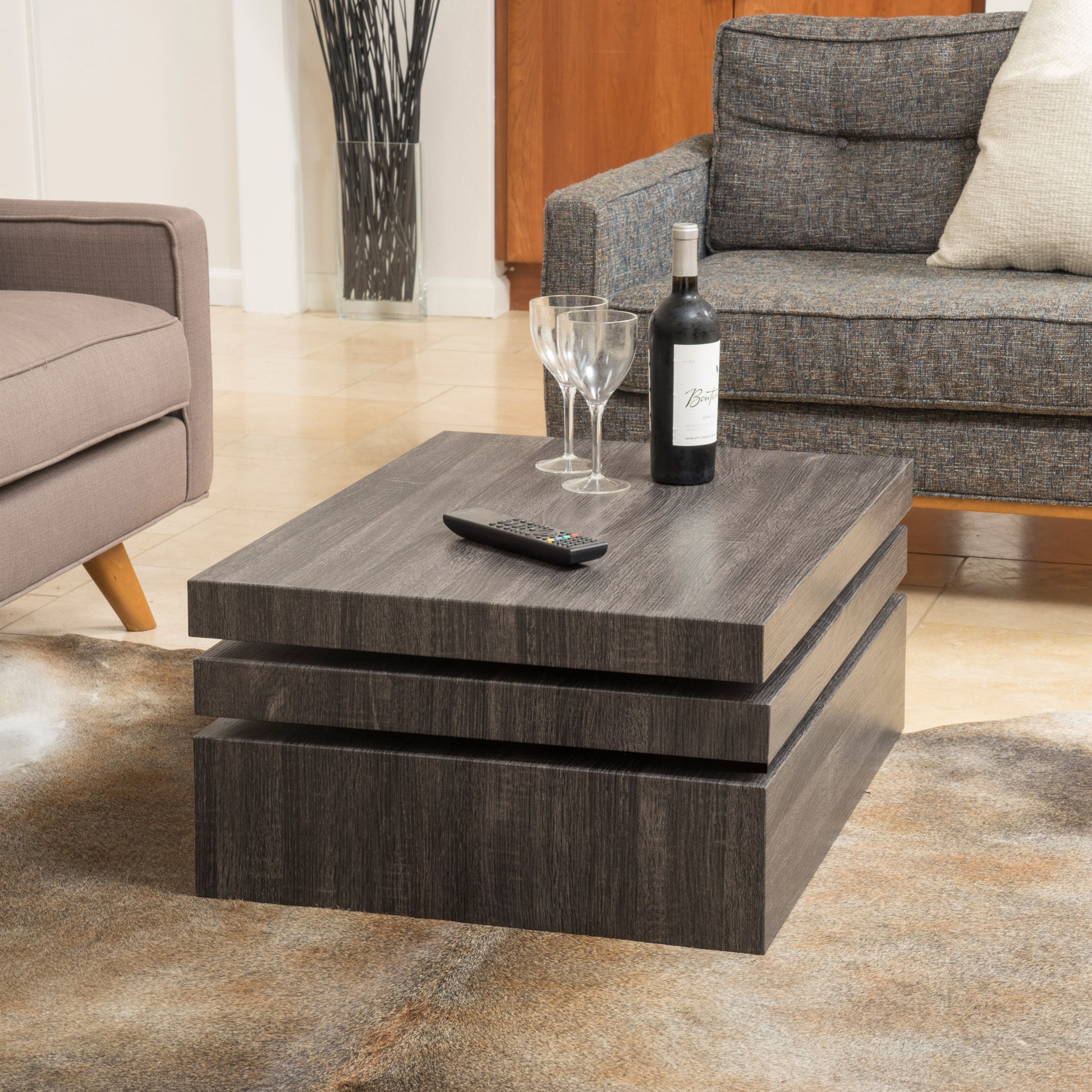 Modern dark wood stacked coffee table with remote and wine glasses