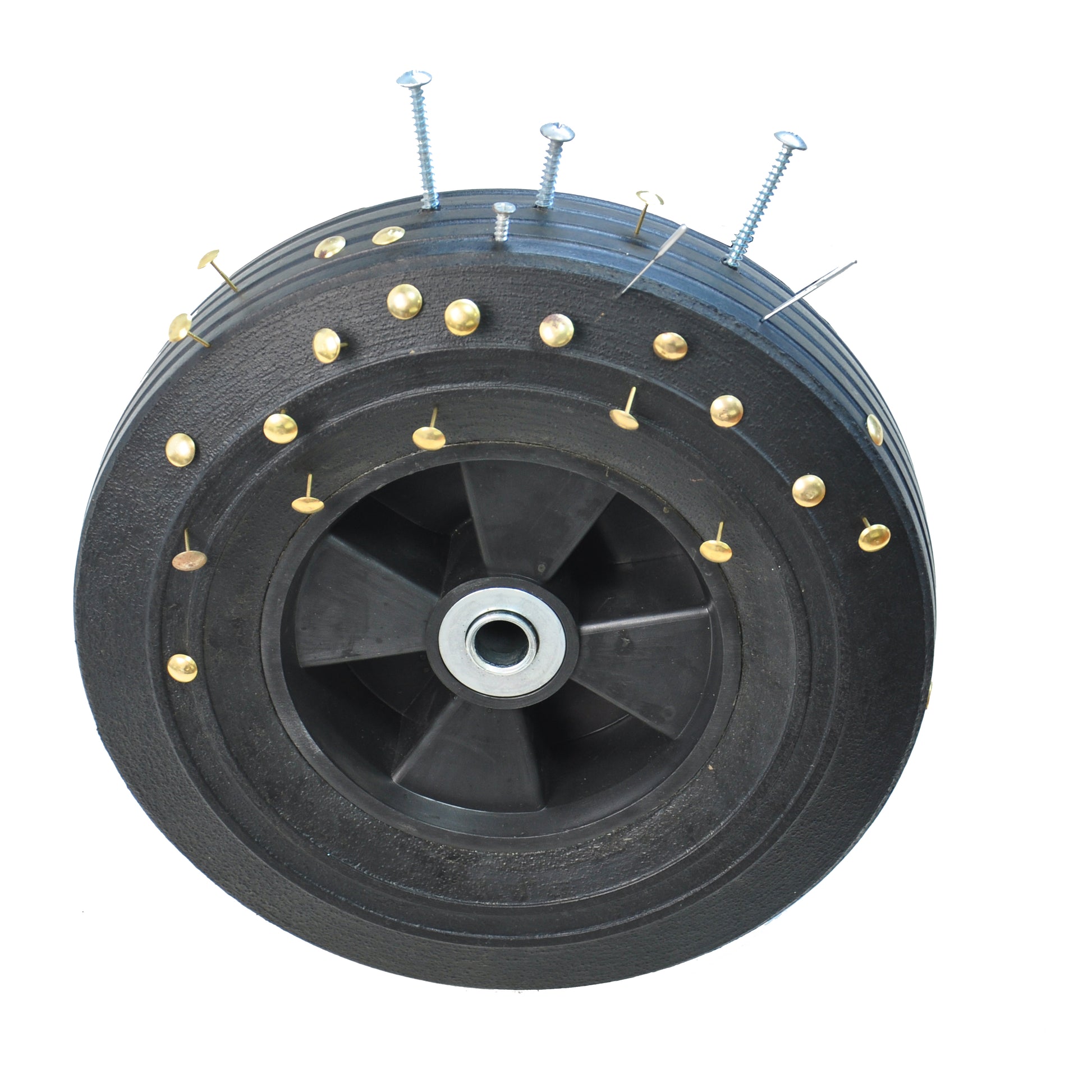 Black rubber tire for a cart studded with gold brass thumbtacks and silver screws