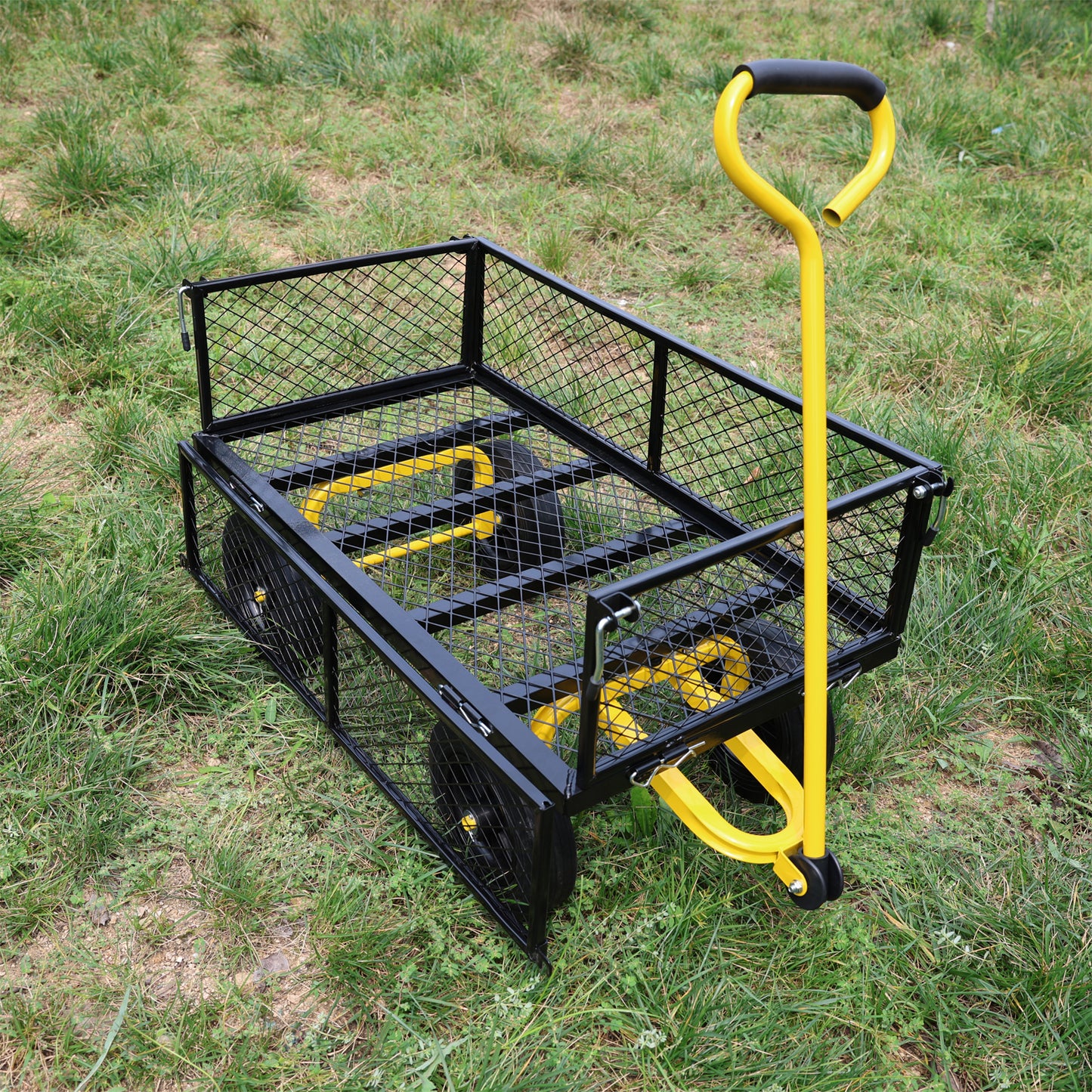 Black metal garden cart with yellow accents and a black handle on a grassy lawn