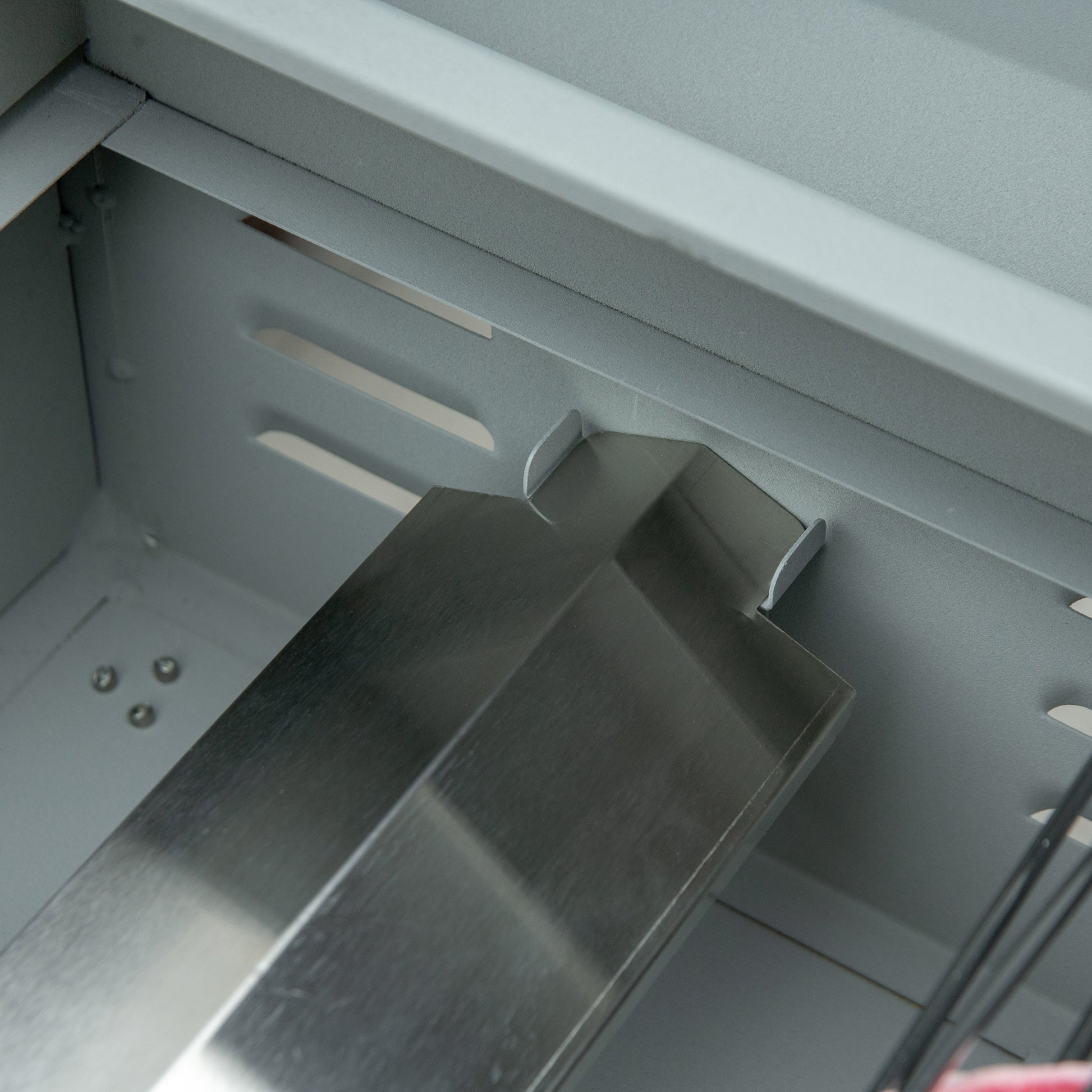 Internal view of a silver metal computer case with drive bay mounts ready for assembly