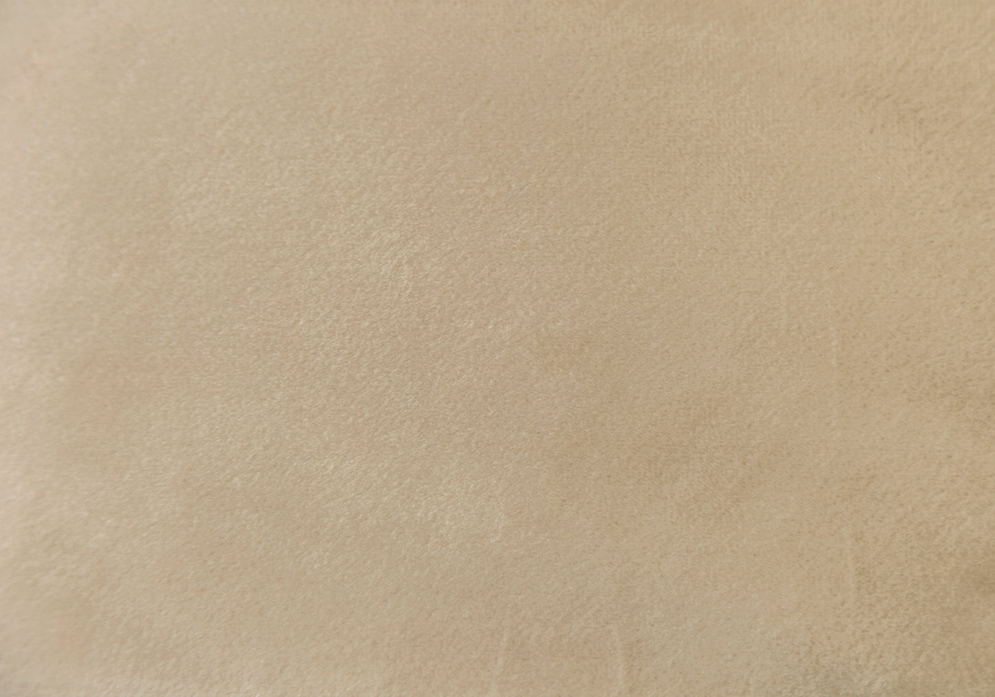 Closeup of soft beige suede fabric texture ideal for upholstery or fashion applications
