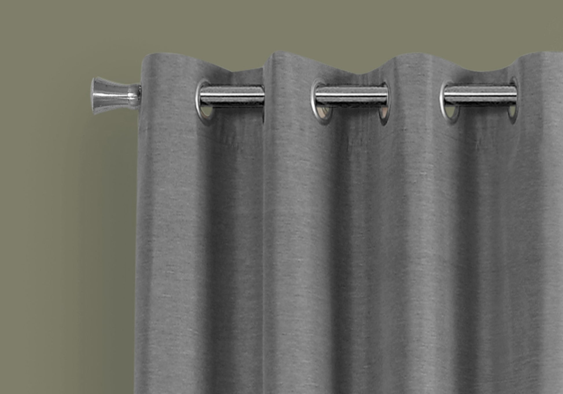 Closeup of a silver grommet curtain rod with textured grey blackout curtains