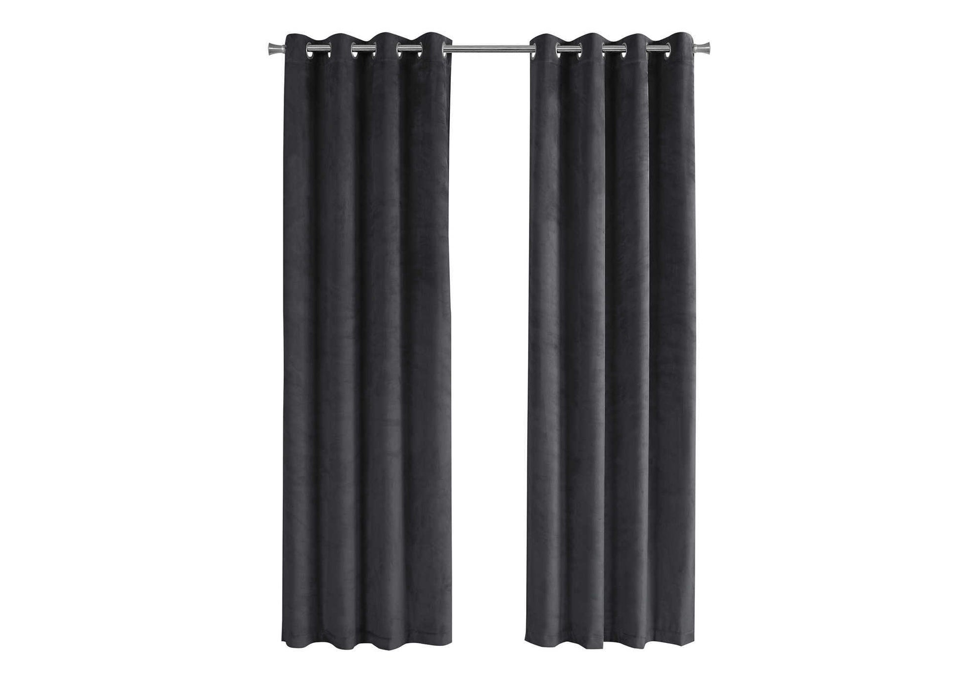 Dark grey velvet grommet curtains hanging on a silver rod for window decor