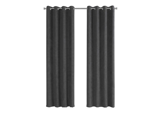 Dark gray velvet blackout curtains with grommets on a curtain rod