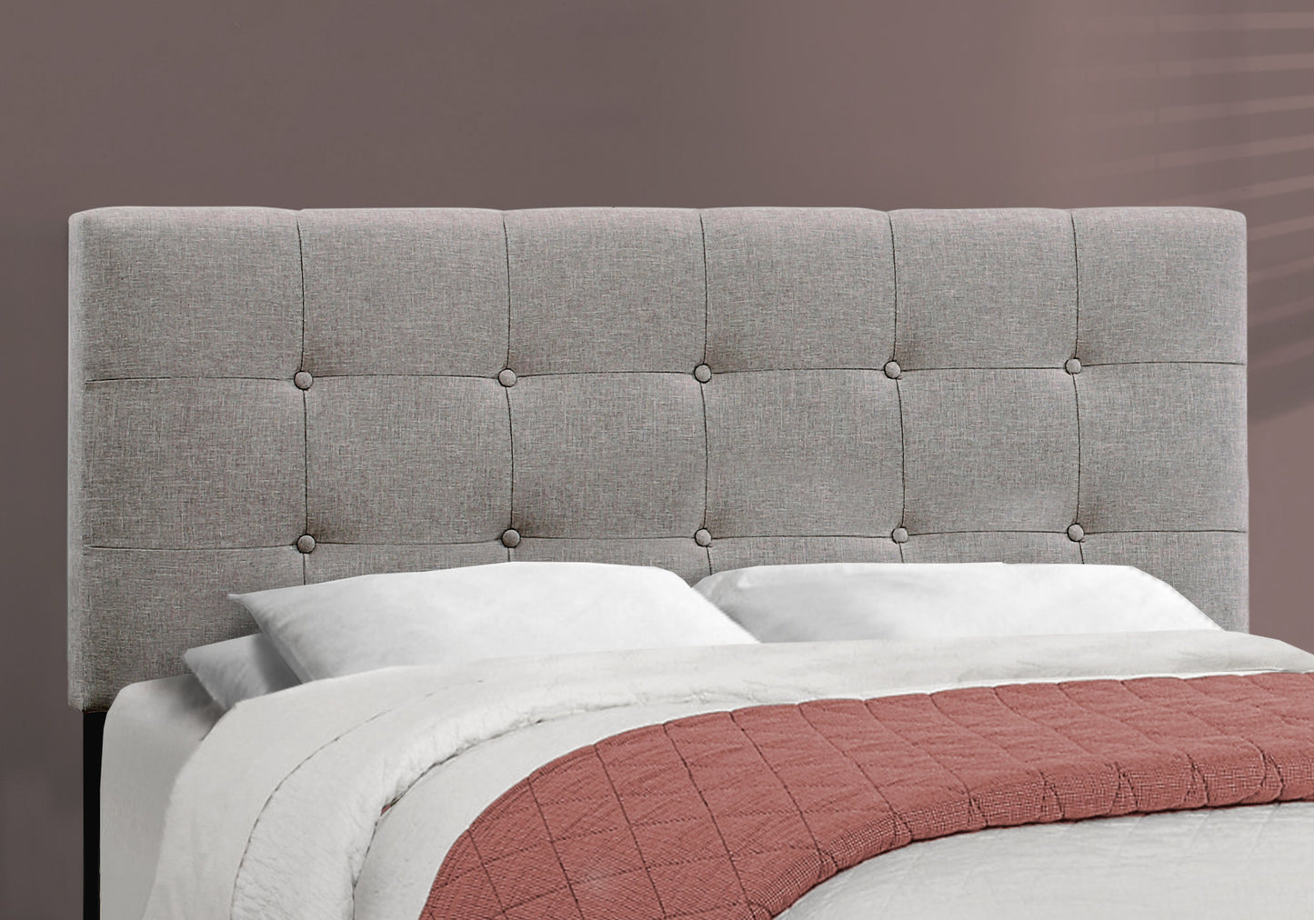 Tufted grey fabric headboard with button details for a modern bedroom