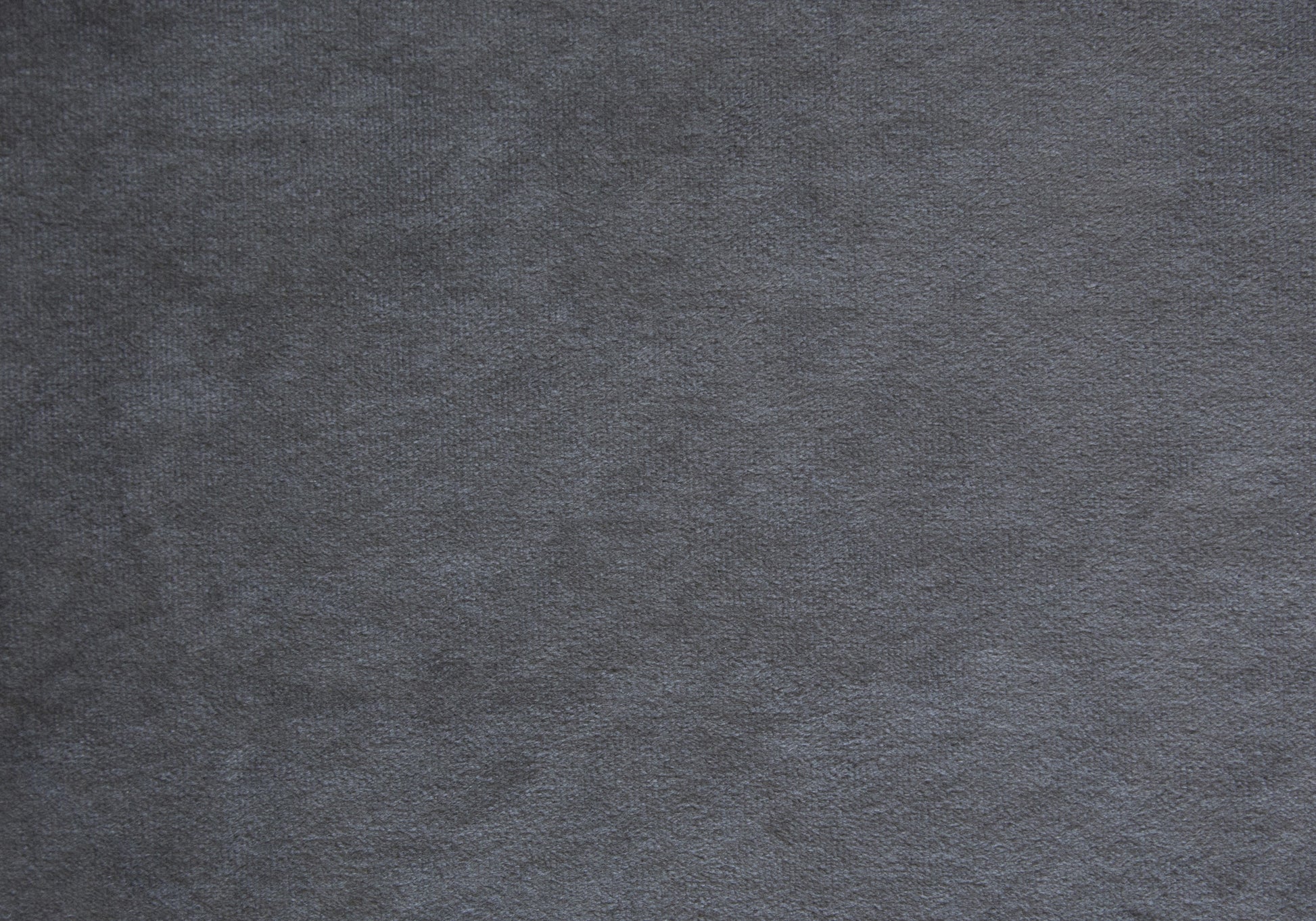 Closeup of textured charcoal grey velvet fabric for upholstery projects