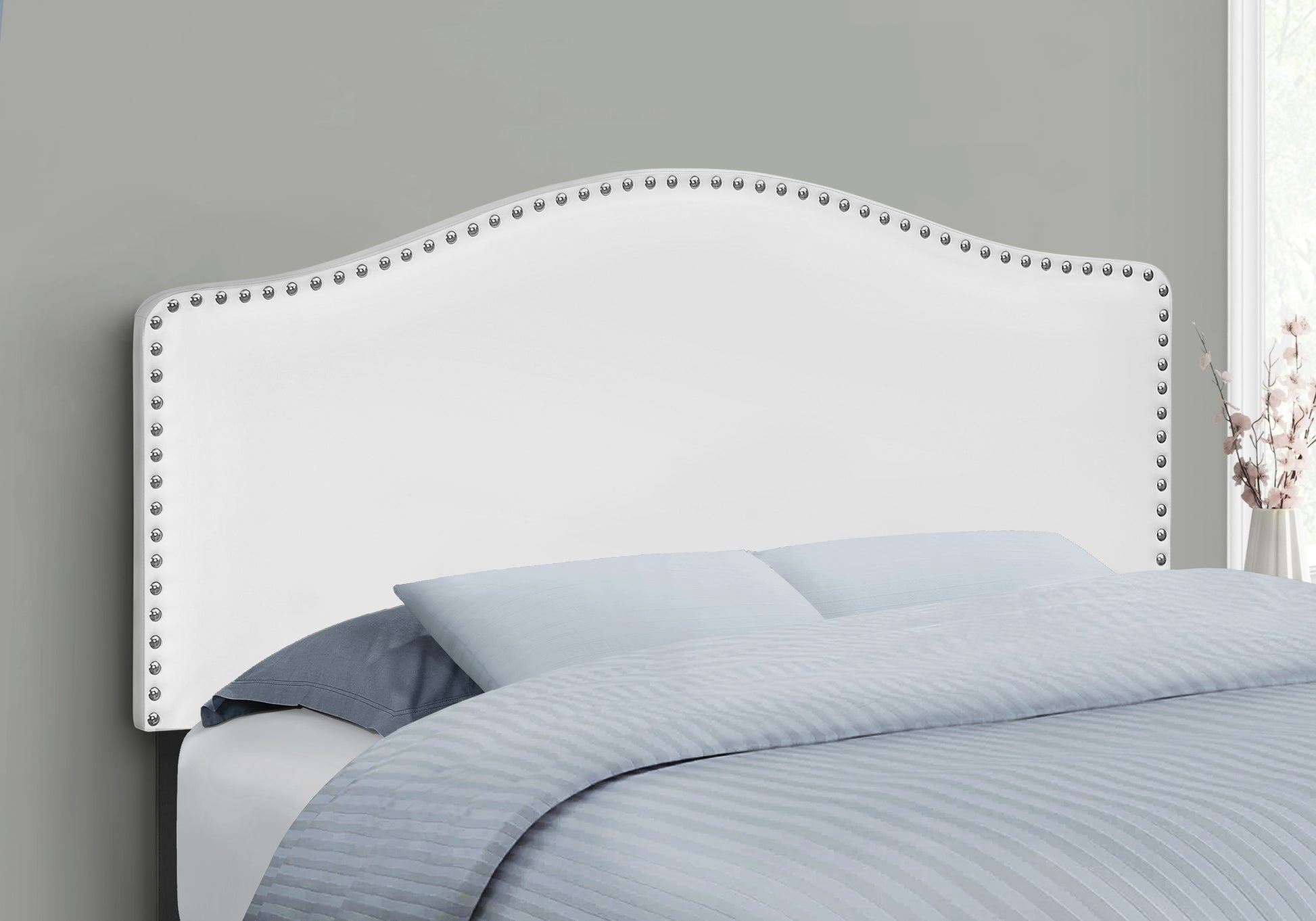 White upholstered headboard with nailhead trim
