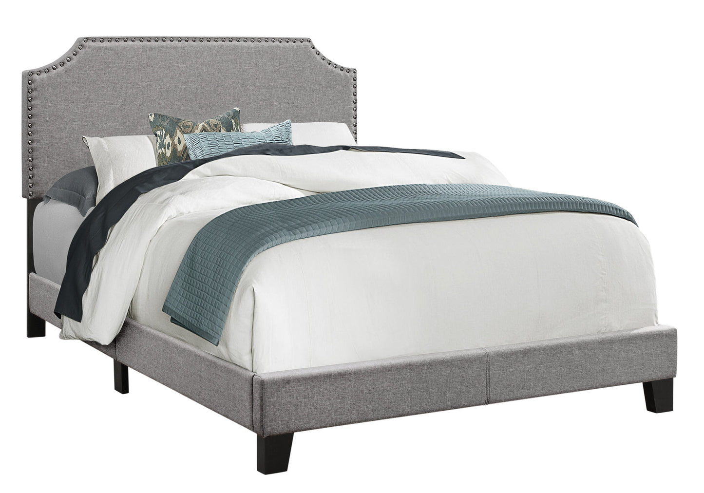 Grey upholstered platform bed with silver nailhead trim and tufted headboard