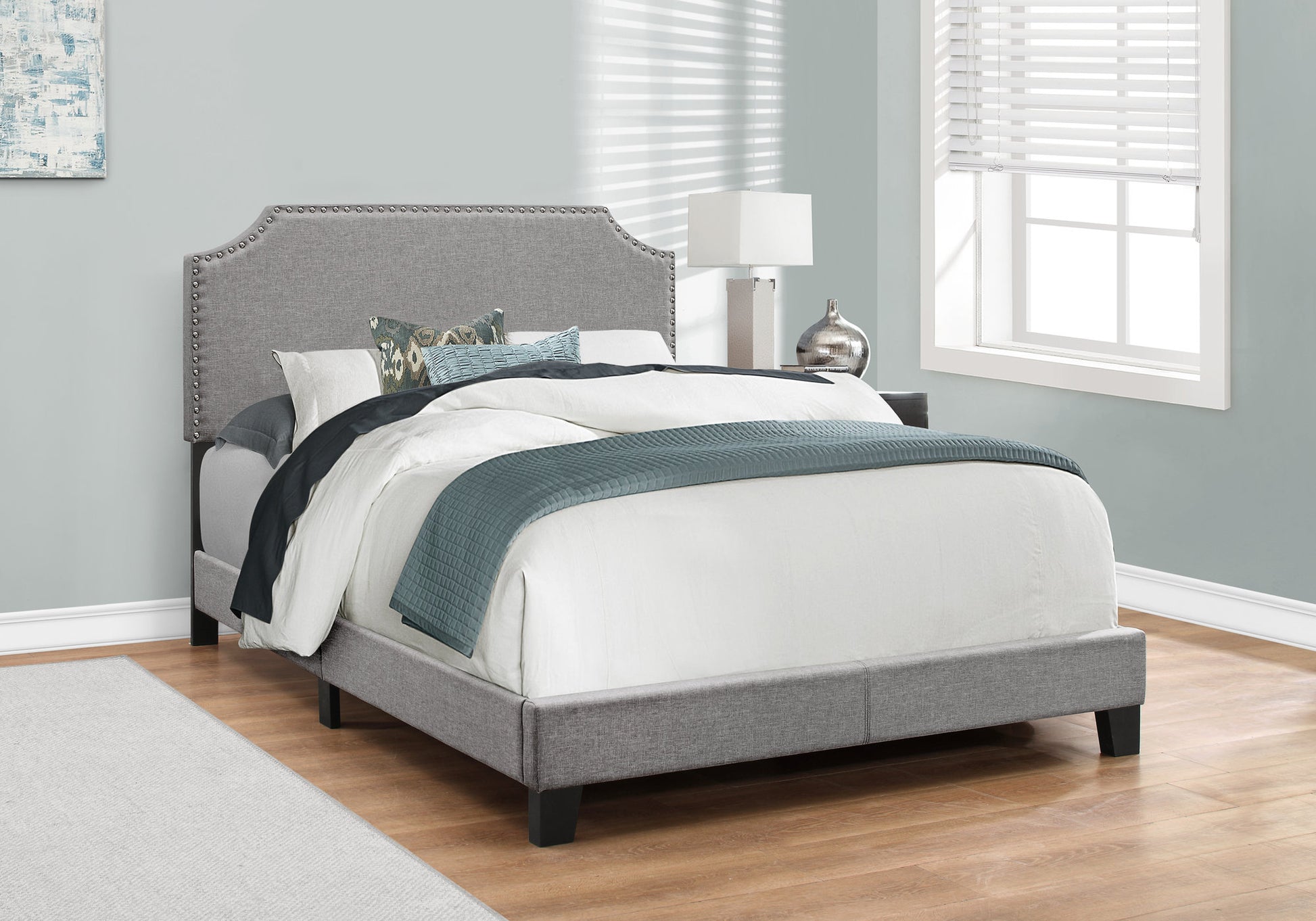 Grey upholstered platform bed with studded headboard for bedroom decor